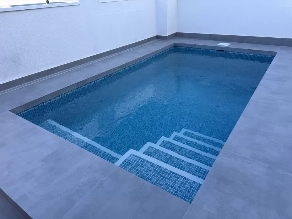 Compact 4×3 m pool in a walled patio with porcelain surround, built by Creator Company in Cabo Roig