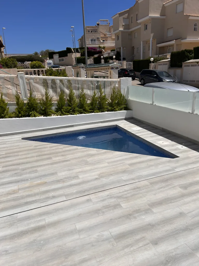 Triangular 3×4 m pool with glass fence and wood-effect porcelain terrace, built by Creator Company in Los Altos
