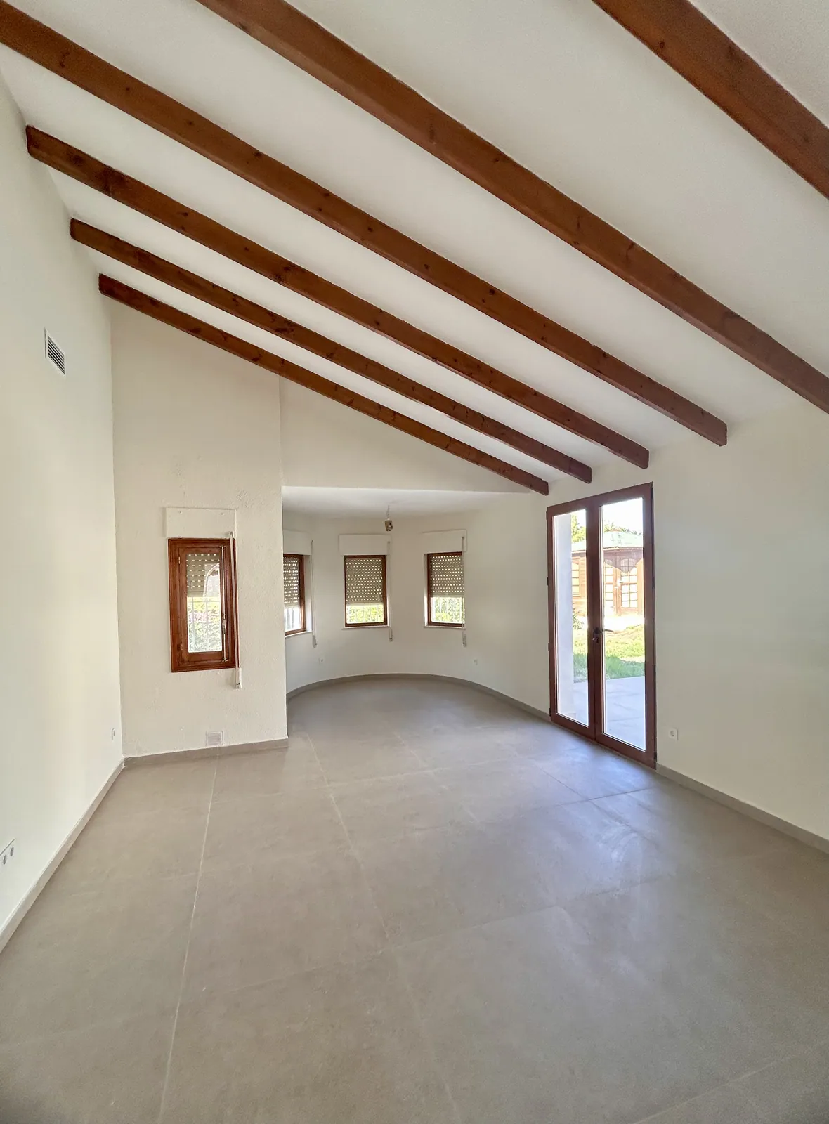 Living room of the renovated country villa in San Miguel de Salinas: exposed timber beams kept, large-format porcelain floor — Creator Company